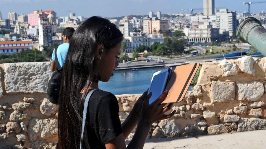 Jovem cubana lê em tablet durante a Feira Internacional do Livro Havana de Havana - Yamil Lage/AFP Photo