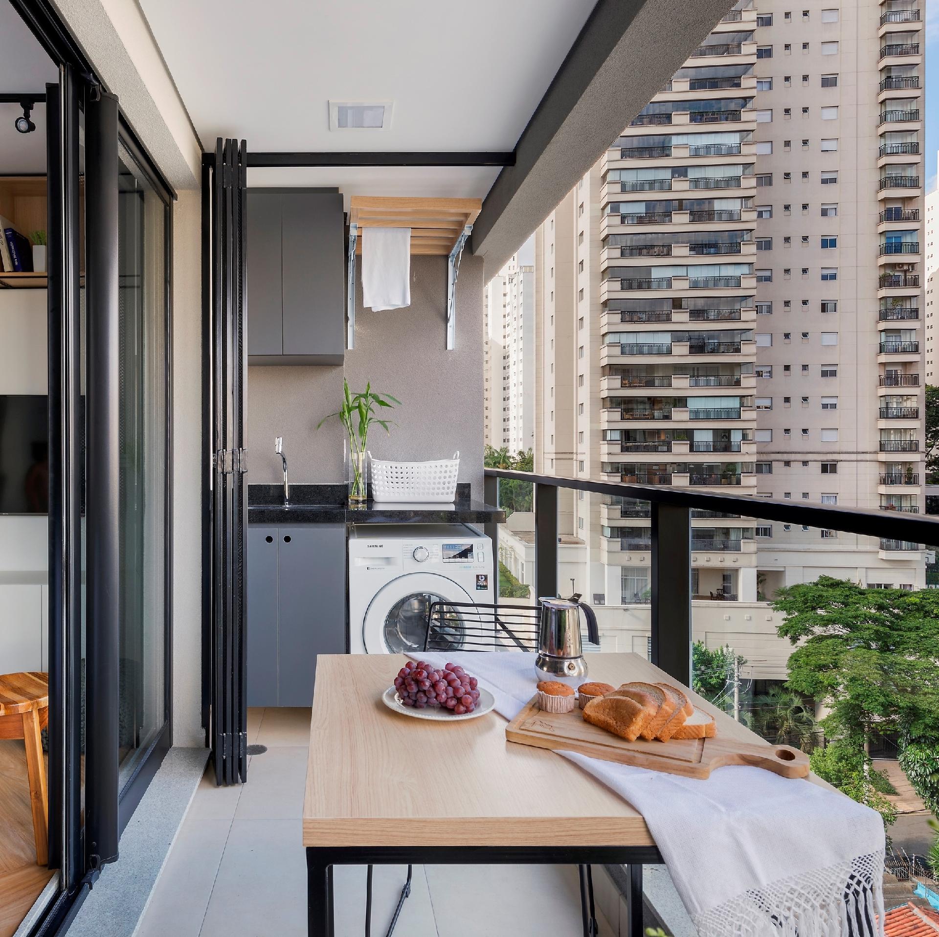 Especialistas em espaços pequenos, as arquitetas da SP Estudio arrumaram um jeito de disfarçar a máquina de lavar roupa e o tanque. Além da marcenaria trazer o mesmo acabamento elegante e sóbrio dos demais ambientes, a dupla criou uma porta metálica para ocultar a lavanderia - Rafael Renzo | Divulgação