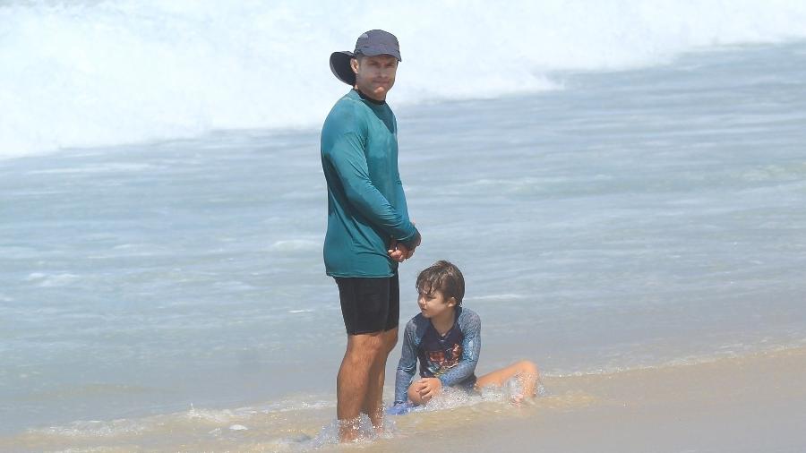 Cláudio Heinrich curte praia com a esposa e o filho Kar na Barra da Tijuca (RJ) - Fabricio Pioyani / AgNews