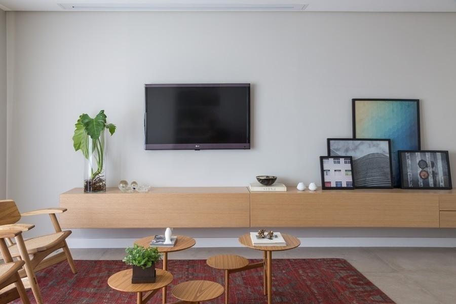 Destaque do living, o bufê minimalista de linhas retas faz às vezes de estante e vai de uma ponta a outra do ambiente. Ele tem 4 metros de comprimento, guarda inúmeros acessórios e serve de apoio para objetos e quadros. Mesa de centro da Marché Art de Vie - Evelyn Müller/Divulgação