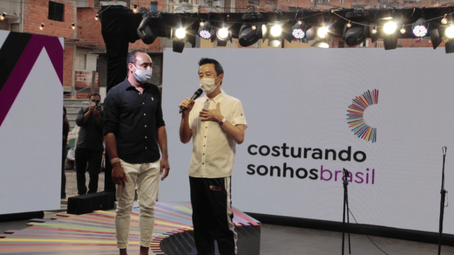 Gilson Rodrigues (esq.), líder comunitário de Paraisópolis, e o estilista Jum Nakao durante apresentação do projeto Costurando Sonhos - Gustavo Lira