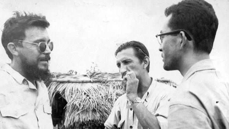 Os irmãos Cláudio (esq.) e Orlando Villas Boas (centro), e Hideo Onaga, repórter das Folhas, no posto avançado de Serra do Cachimbo da Expedição Roncador/Xingu, no Rio das Mortes. A expedição tinha por objetivo abrir caminho em direção do Amazonas, construindo campos de pouso para aviões. A partir dessa expedição, iniciada em 1943, foram mapeadas aldeias indígenas e consolidado o Parque Nacional do Xingu, criado por lei em 1961 - Antonio Pirozzelli/Folhapress - Antonio Pirozzelli/Folhapress