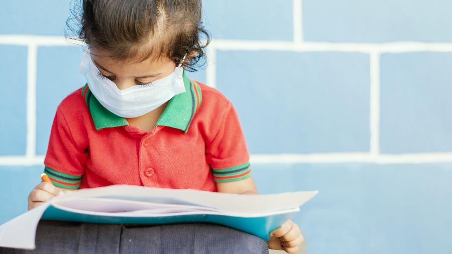 Criança na escola pandemia coronavírus - iStock