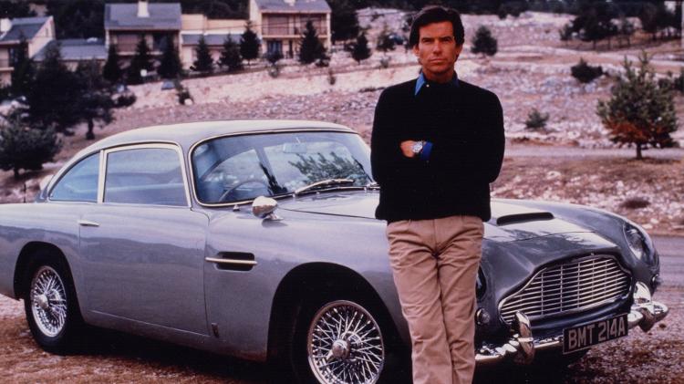 Pierce Brosnan posa na frente do Aston Martin usado em "007 Contra GoldenEye" - Reprodução - Reprodução