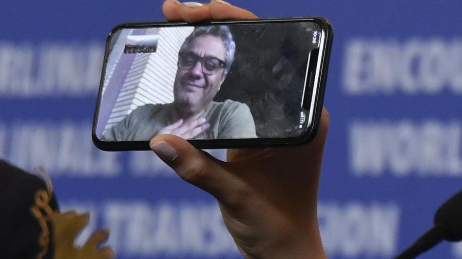 Iranian actress Baran Rasoulof holds a phone displaying Iranian director Mohammad Rasoulof who was awarded the "Golden Bear for Best Film" attends a press conference after the awarding ceremony of the 70th Berlinale film festival in Berlin on February 29, 2020. (Photo by John MACDOUGALL / AFP)