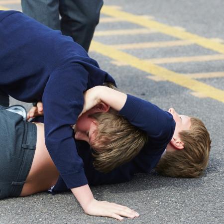 Briga entre alunos em pátio de escola - Getty Images/iStockphoto