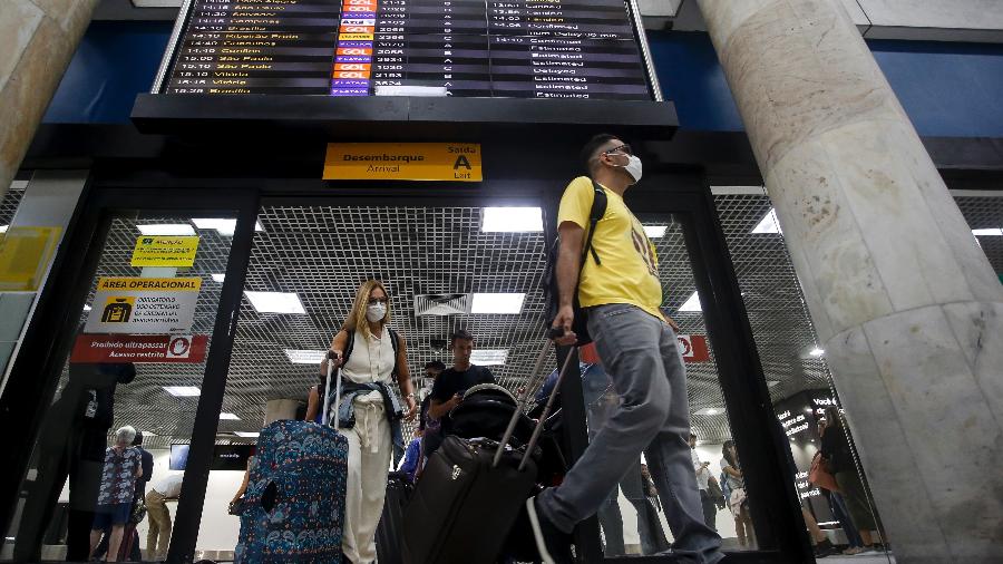 Passageiros de máscara desembarcam no aeroporto Santos Dumont, no Rio - Bruna Prado/Getty Images