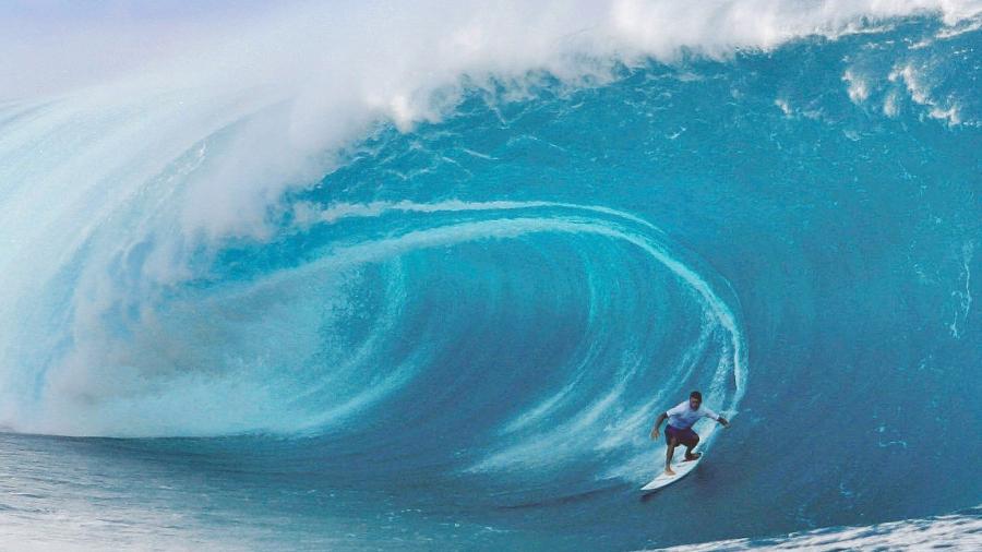 Cory Lopez, dos EUA, em um enorme tubo em Teahupo'o, conhecida por ondas perfeitas e perigosas