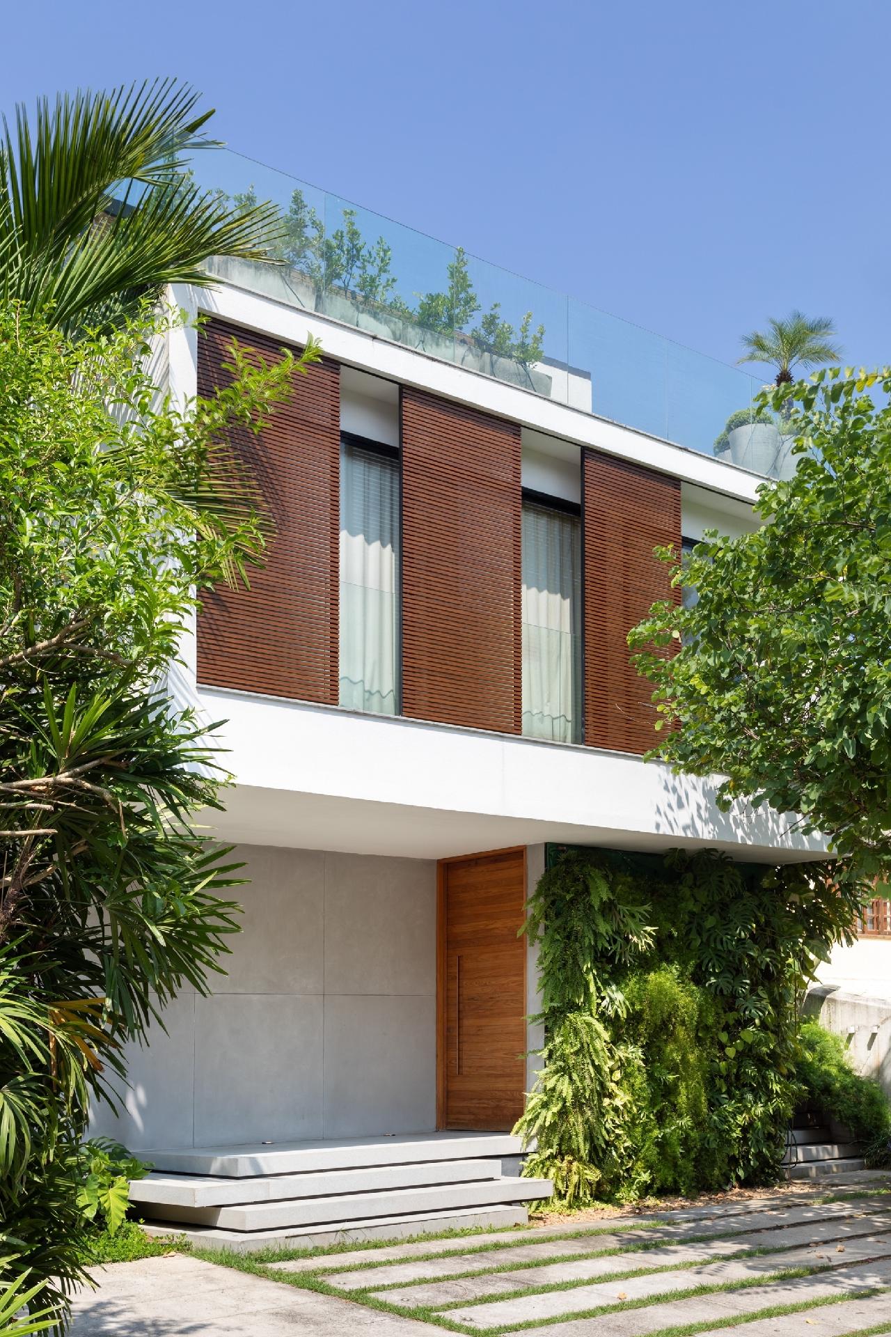 "Nosso objetivo na fachada da frente foi minimizar a incidência do sol da tarde com vegetação alta e painéis de correr com função de brises. Esses recursos também trouxeram privacidade para a área interna da casa, já que o condomínio não permite a construção de muros", explica Gustavo. - Luiza Schreier/Divulgação