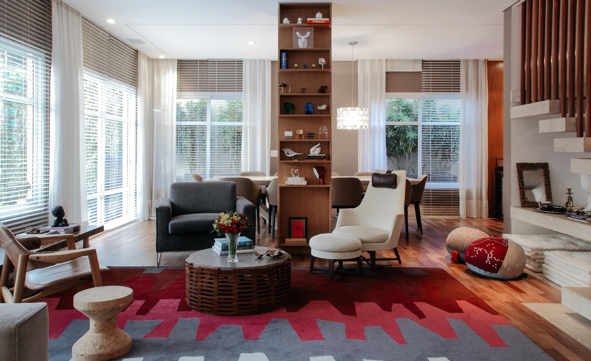 Na integração entre as salas (estar à frente e jantar atrás) havia um pilar que não podia ser removido. Para contornar a situação, os profissionais da MF Arquitetos projetaram um móvel ao redor da estrutura, que serve de um lado para expor objetos de decoração e do outro como armário para louças - Hamilton Penna / Divulgação