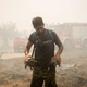 Homem salvando duas tartarugas do incêndio na Grécia, em 19 de julho de 2023. Depois de três dias, os bombeiros ainda estão lutando contra as chamas em Nea Zoi - NurPhoto via Getty Images - NurPhoto via Getty Images