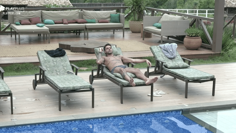Diego Grossi descansa na área da piscina em A Fazenda 2019 - Reprodução/PlayPlus