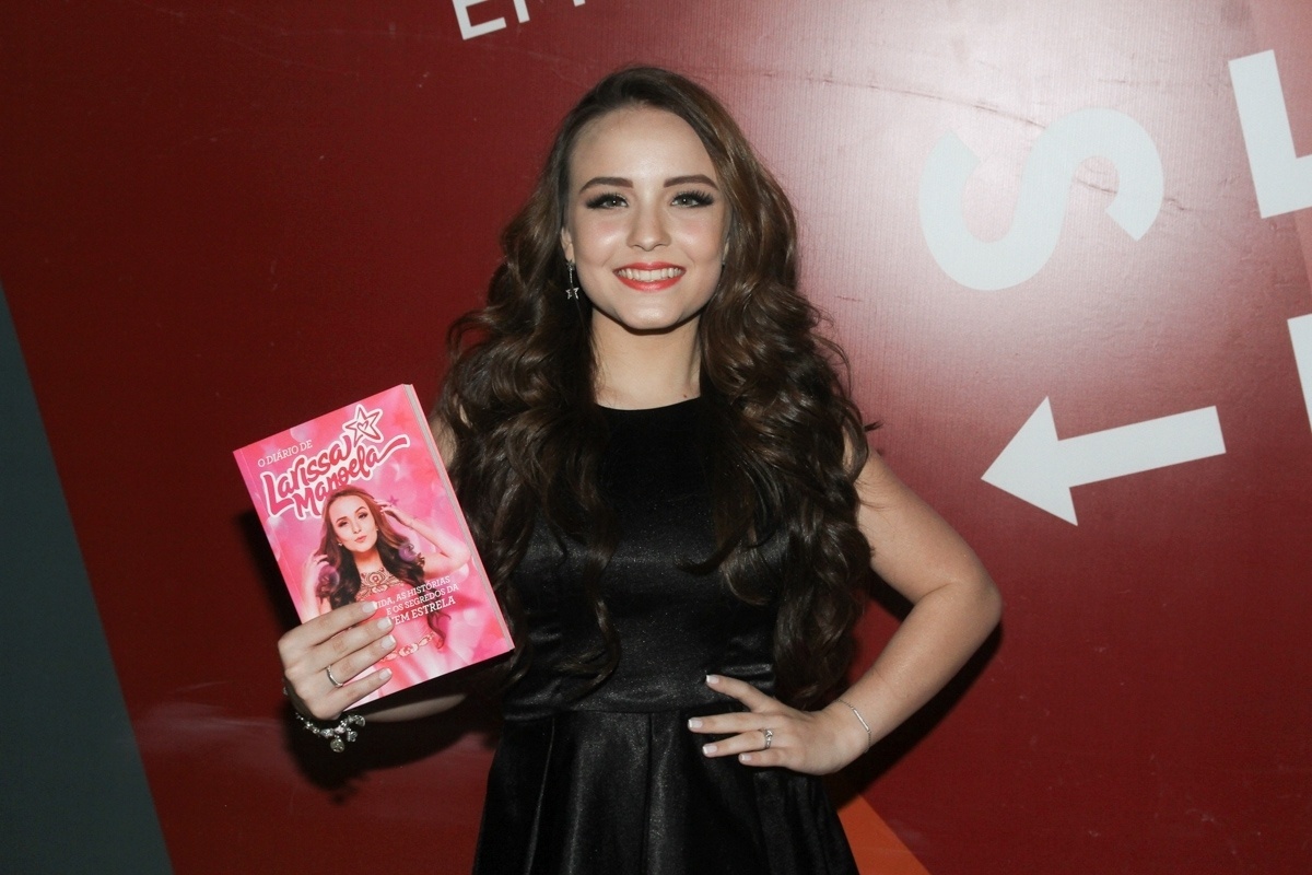 1º.set.2016 - Larissa Manoela posa com o seu primeiro livro, "O Diário de Larissa Manoela" antes de iniciar a sessão de autógrafos na Bienal de SP - Amauri Nehn/Brazil News
