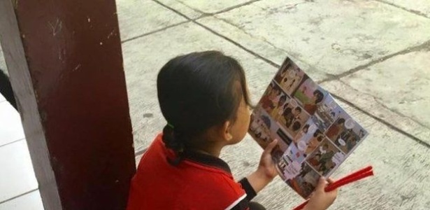 Menina indonésia lê quadrinhos que alertam para tráfico humano - Reprodução/BBC - Reprodução/BBC