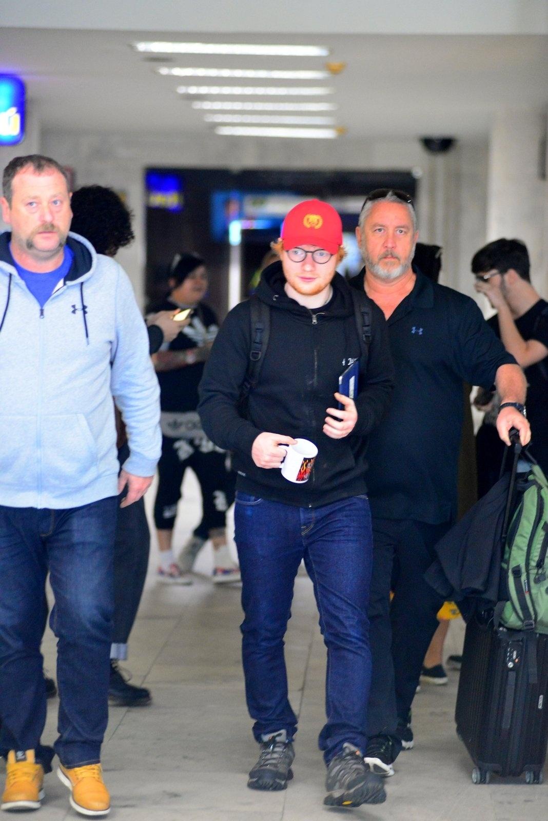 De boné vermelho, Ed Sheeran desembarca no aeroporto Santos Dumont, no Rio. O cantor se apresenta nesta quinta-feira na cidade - William Oda /AgNews
