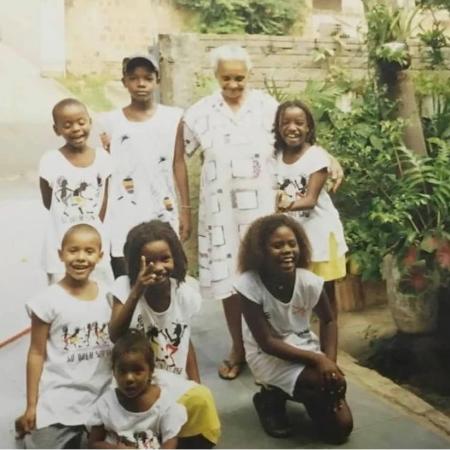 Abaixada à frente e de saia amarela, Semayat em reunião com os primos na casa da avó, Gabriela, em pé ao fundo. Todos vestem as roupas da marca da família, a Kekerê. - Arquivo pessoal - Arquivo pessoal