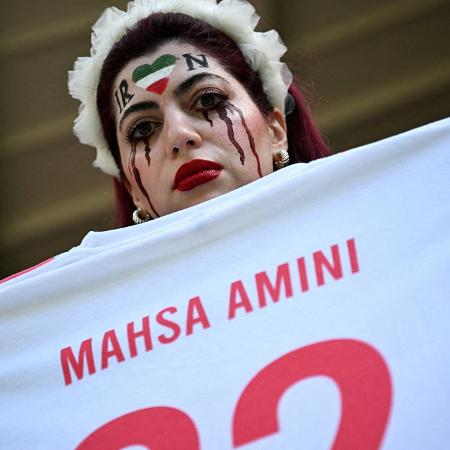 Mulher segura camiseta com o nome de Mahsa Amini