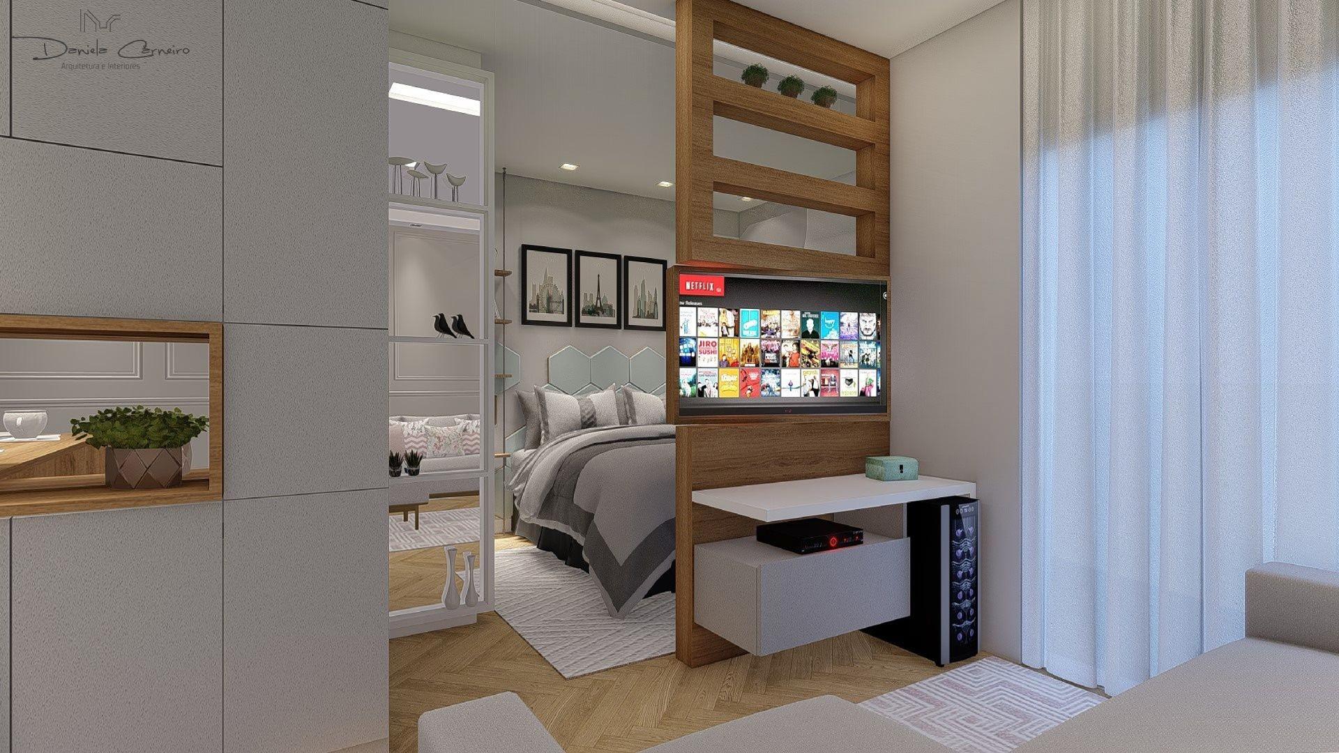 Eis mais uma intervenção bonita e versátil: neste apartamento integrado de 32 m², a arquiteta Daniela Carneiro criou uma prateleira (feita de marcenaria) para acomodar a TV, instalada em um suporte giratório. Assim, é possível que a tela seja vista tanto a partir do quarto quanto da sala, de acordo com a vontade do morador. - Divulgação