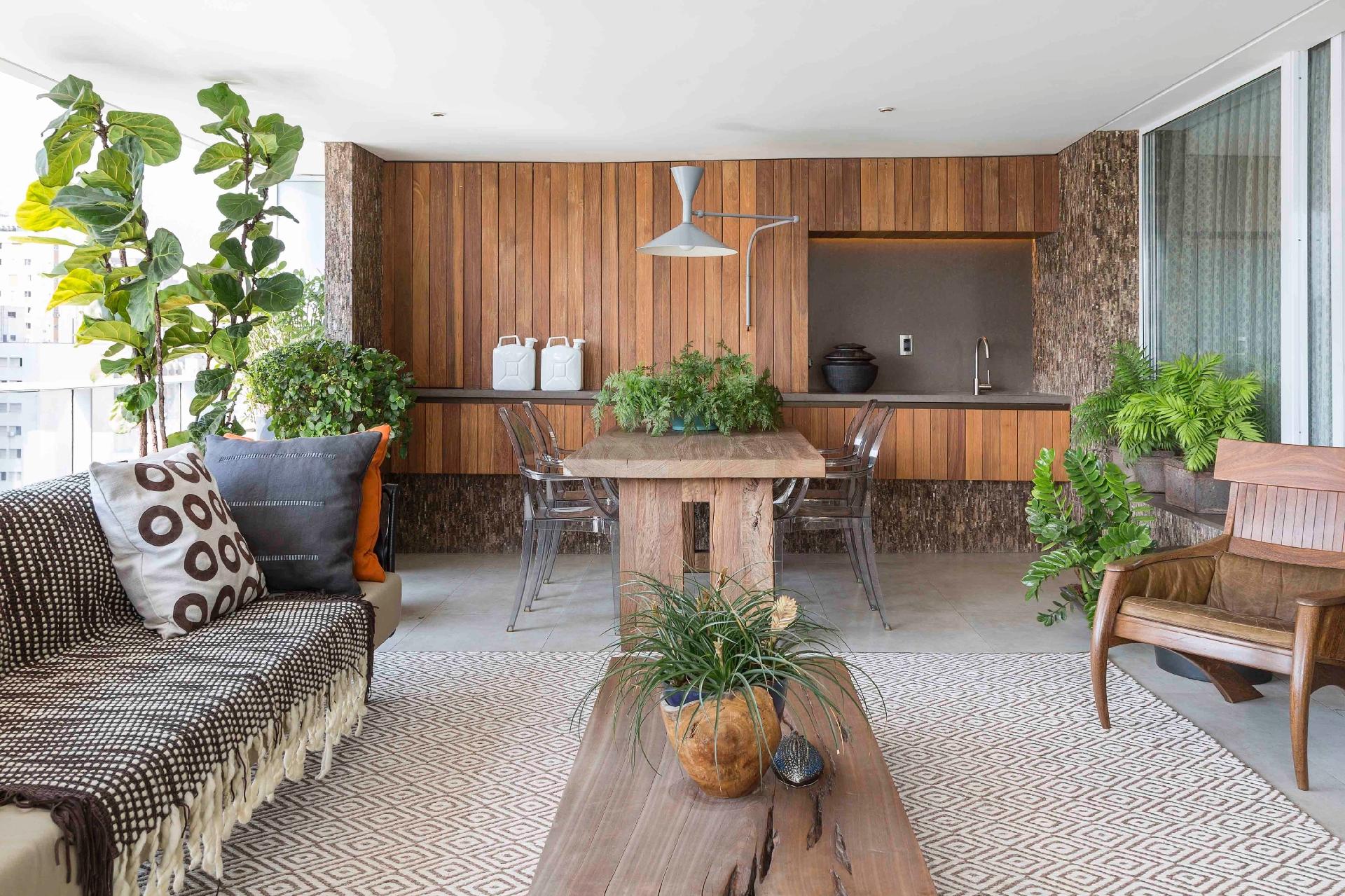 Mesa de jantar de madeira bruta, o sofá e as poltronas arrematam a decoração rústica e moderna - Júlia Ribeiro/Divulgação