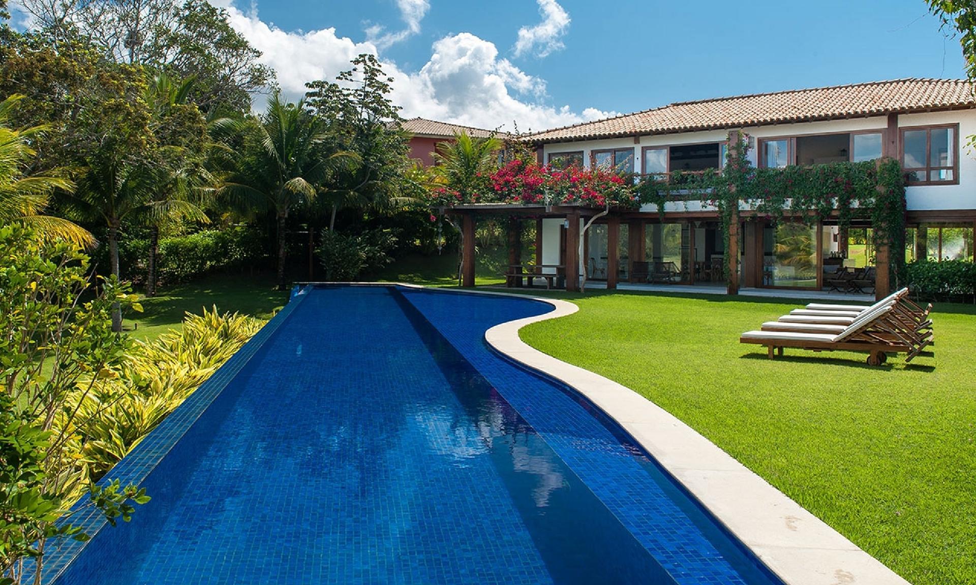 Os ambientes sociais da casa em Trancoso, Porto Seguro (BA), estão integrados à área de lazer. Inserida no centro do terreno, a piscina tem 25 m de comprimento e borda infinita. O escritório Conrado Ceravolo Arquitetos assina o projeto - Divulgação