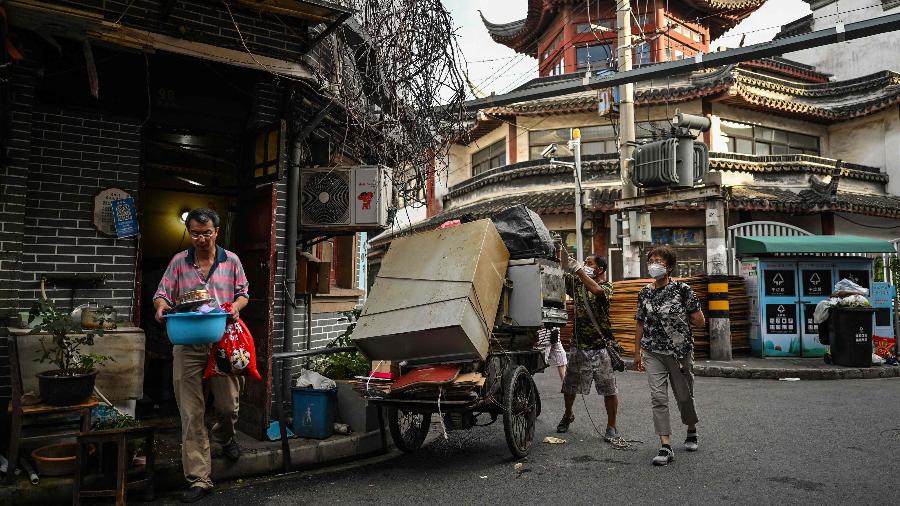 Um colecionador compra mobílias antigas e outras relíquias dos moradores que deixam Laoximen antes da destruição do bairro - HECTOR RETAMAL/AFP