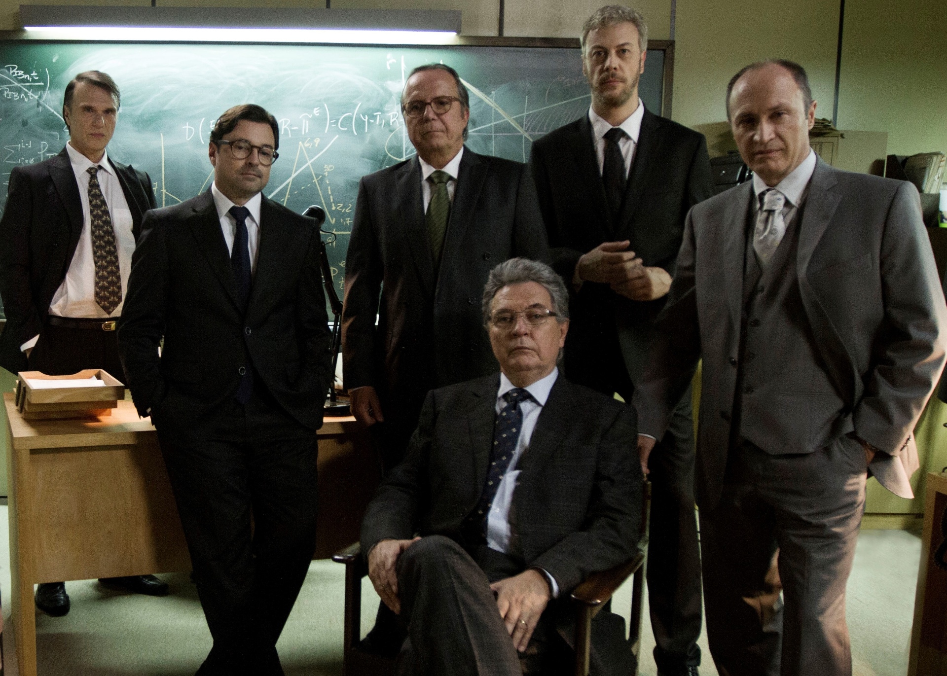 A equipe econômica do Plano Real nas telas: Winston Fritsch (Fernando Eiras), Gustavo Franco (Emilio Orciollo Netto), Pedro Malan (Tato Gabus Mendes), Fernando Henrique Cardoso (Norival Rizzo, sentado), Persio Arida (Guilherme Weber) e Andre Lara Resende (Wladimir Candini) - Divulgação