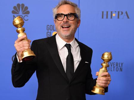 Alfonso Cuaron posa com seus Globos de Ouro - Mark Ralston/AFP