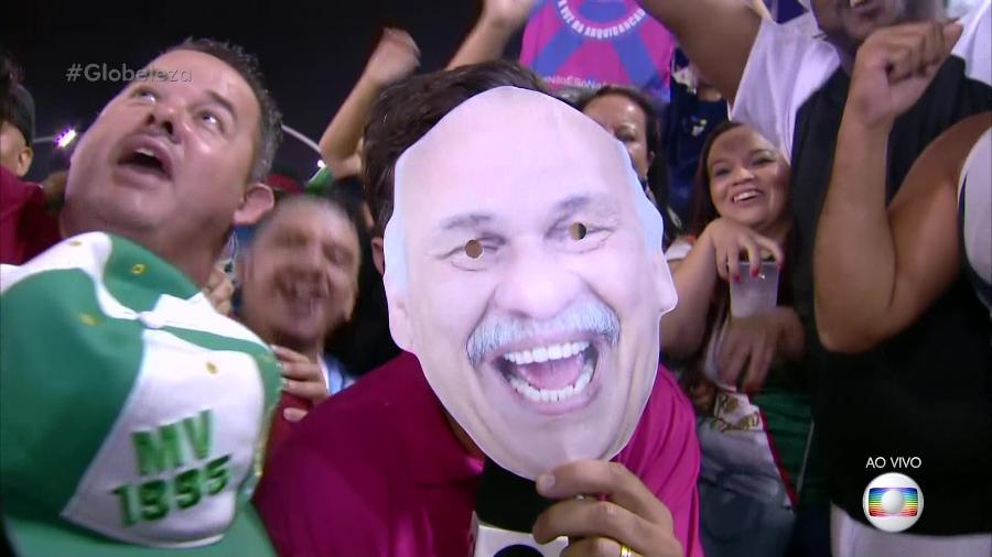 O repórter Marcelo Poli usa máscara de Márcio Canuto durante transmissão do Carnaval de São Paulo na Globo - Reprodução/TV Globo