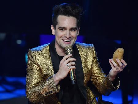 Brendon Urie, líder do Panic! At The Disco, segura uma batata durante show no festival iHeartRadio, em Burbank, na Califórnia - Robyn Beck/AFP