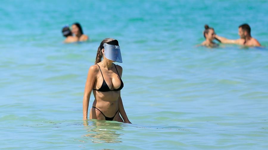 Mulher usa escudo facial em reabertura das praias de Miami, nos Estados Unidos - Getty Images