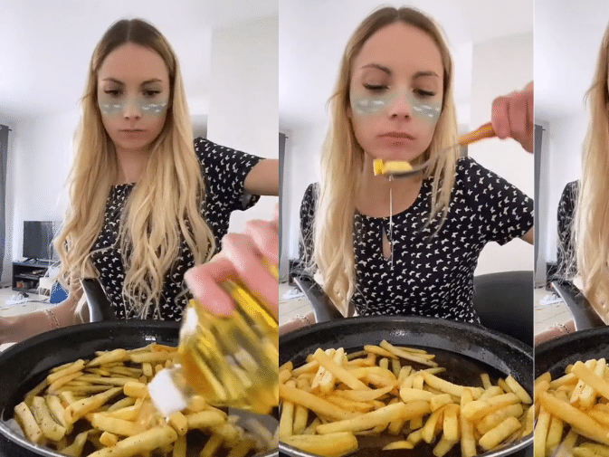 Mulher jovem comendo batata frita assistindo filme na mesa azul