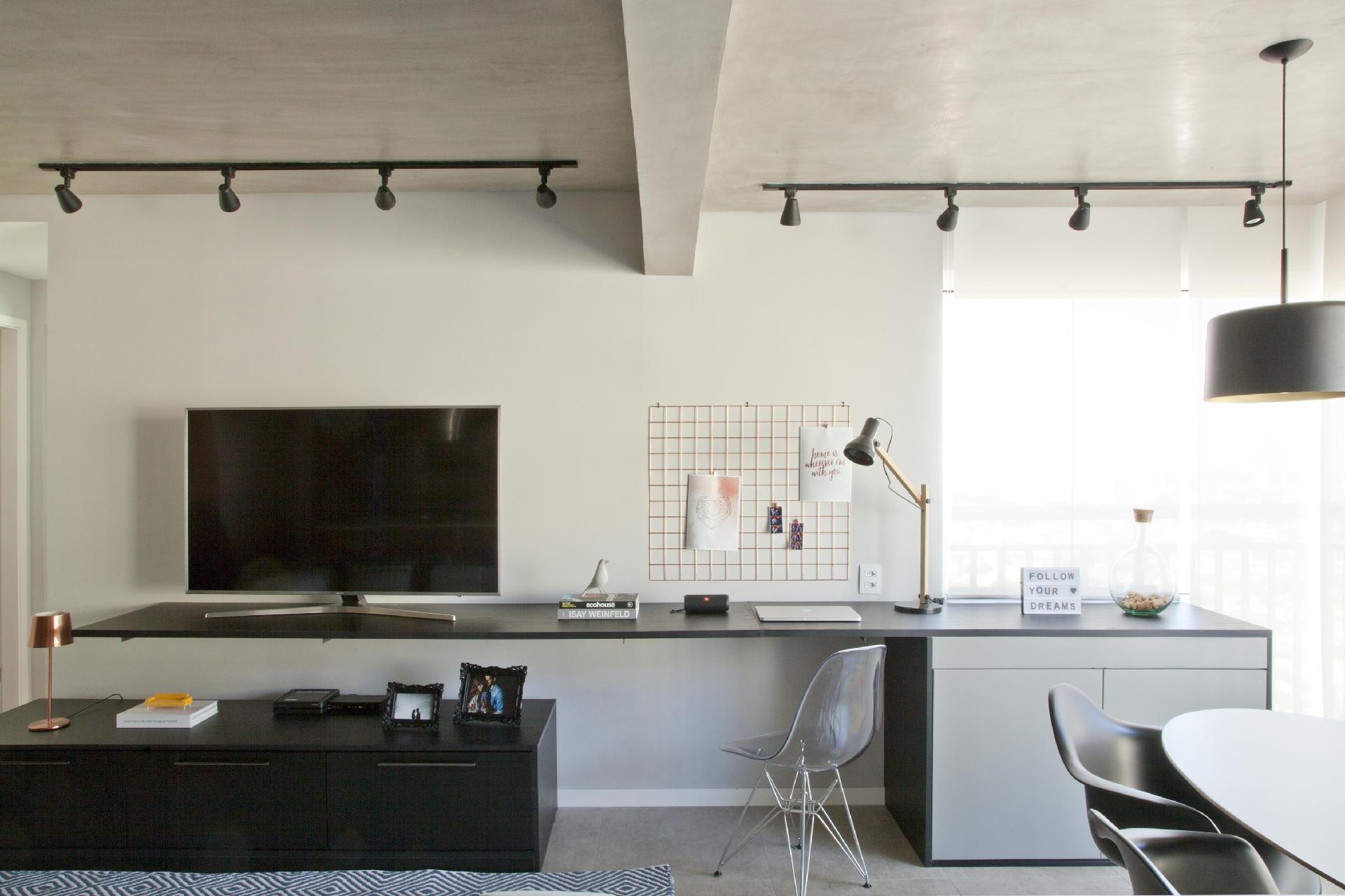 Com a integração da varanda à ala social do apartamento, surgiu um problema: onde esconder a condensadora do ar-condicionado? A alternativa sugerida pelo arquiteto Bruno Moraes foi criar bancada para a sala (4,85 m de comprimento), que concentra a TV, serve de apoio para trabalhar em casa e perto da janela vira um armário para ocultar o equipamento. Para acessar, basta abrir as duas portas - Luis Gomes |Divulgação