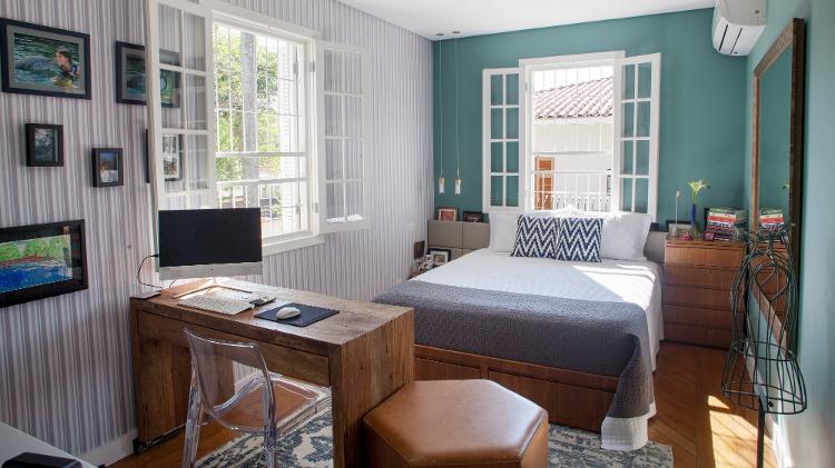 Os moradores queriam um quarto colorido, alto astral e confortável para conciliar descanso e trabalho, o que levou a arquiteta Juliana Fabrizzi (https://www.instagram.com/julianafabrizzi_arquitetura/) a propor a combinação de uma cor alegre (verde, de média intensidade) com a delicadeza do tecido de parede cinza e branco, tornando o espaço bastante acolhedor. A boa iluminação era ponto crucial e, por isso, a mesa de trabalho foi posicionada perto da janela para entrada de luz natural.  - Ricardo Durand - Ricardo Durand