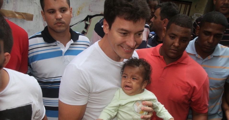 29.set.2015- Rodrigo Faro tira foto com um bebê no colo durante gravação no Vidigal, zona sul do Rio 