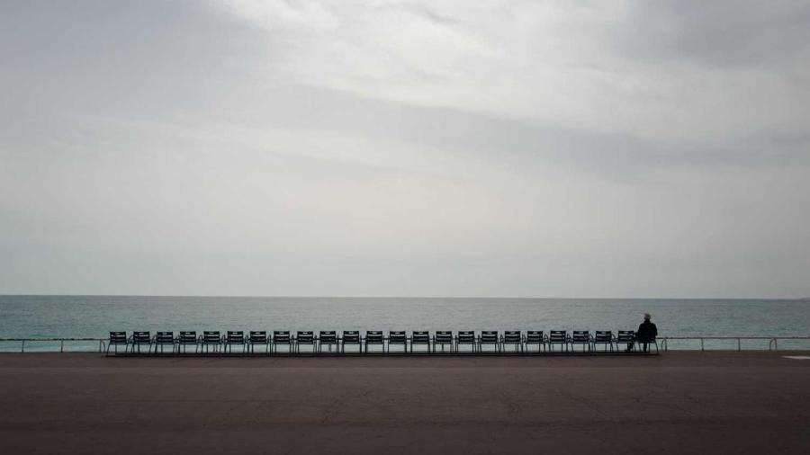 Homem observa o Mediterrâneo na avenida Promenade des Anglais, em Nice, na França - VALERY HACHE/GETTY