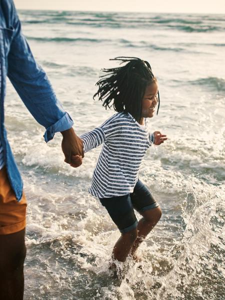 Pai e filha caminham no mar - pixdeluxe/Getty Images