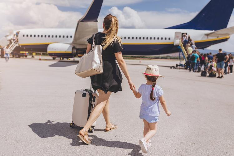 Mãe e filha embarcam em avião - FluxFactory/Getty Images - FluxFactory/Getty Images