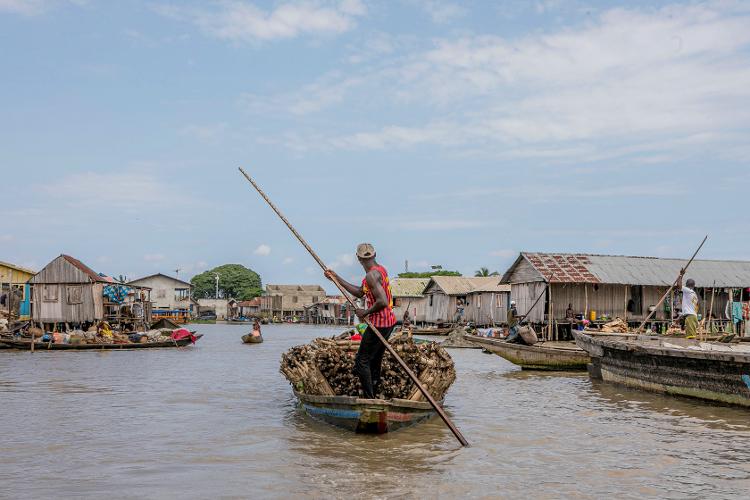 Homem andando de canoa por Ganvié, no Benin