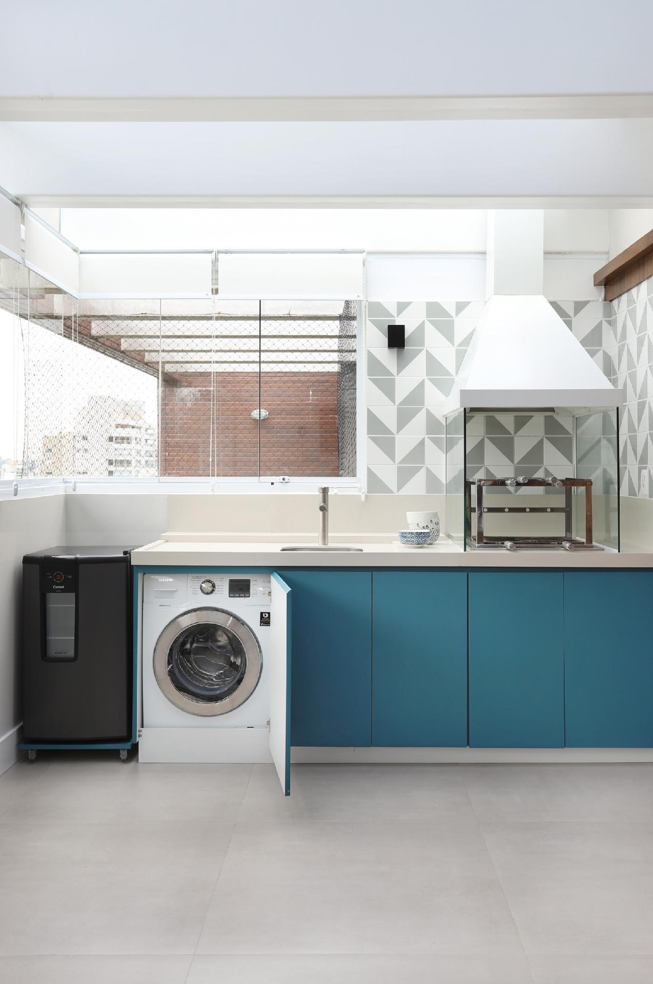 Já que o edifício dispõe de uma lavanderia coletiva, os donos deste apartamento abriram mão desse ambiente, mas fizeram questão de ter, pelo menos, uma máquina lava e seca. Para disfarçá-la na varanda gourmet, os arquitetos Felipe Luciano e Vanessa Keiko, do Estudio FCK, reservaram uma das partes do gabinete de marcenaria de apoio à churrasqueira. É só fechar a porta e o equipamento some - Mariana Orsi | Divulgação