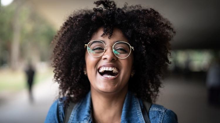 Jovem sorrindo, gargalhada, risada - iStock - iStock
