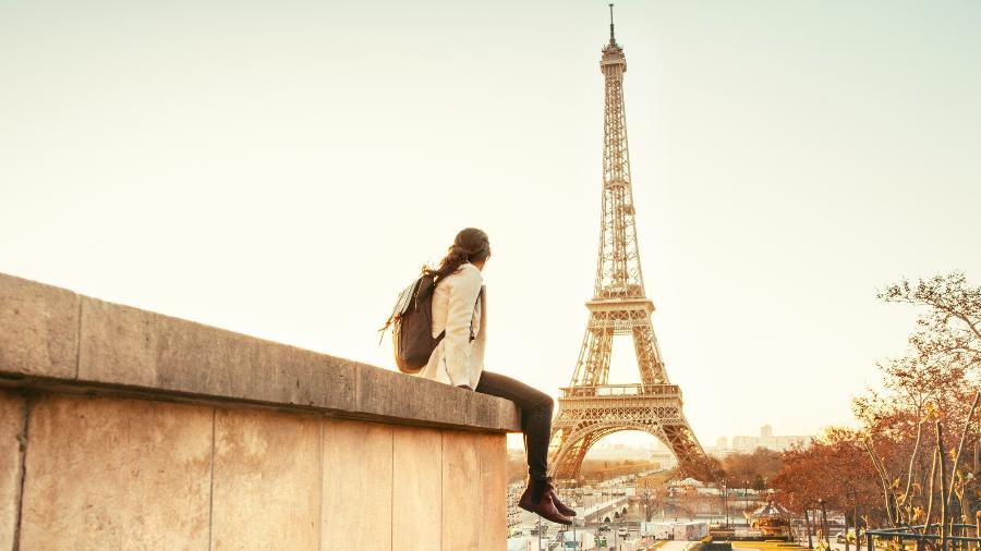 Turista observa a Torre Eiffel, maior cartão-postal de Paris: marco do retorno dos turistas foi o feriado de Páscoa - Getty Images
