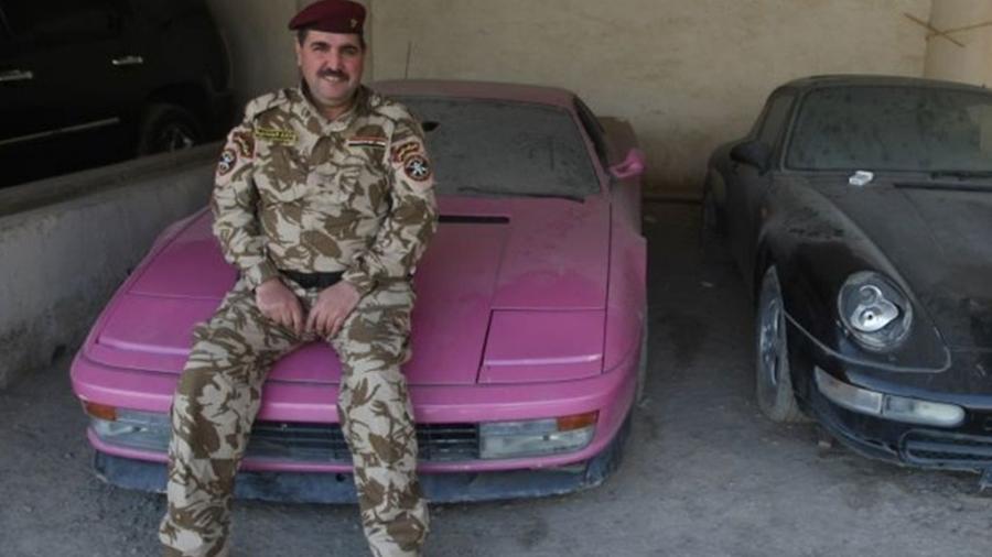 Militar iraquiano posa com Ferrari Testarossa rosa que pertenceu a Uday Hussein após Saddam ser retirado do poder em 2003 - AFP
