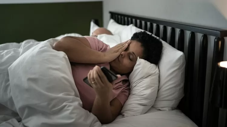 mulher mexendo no celular na cama - iStock - iStock