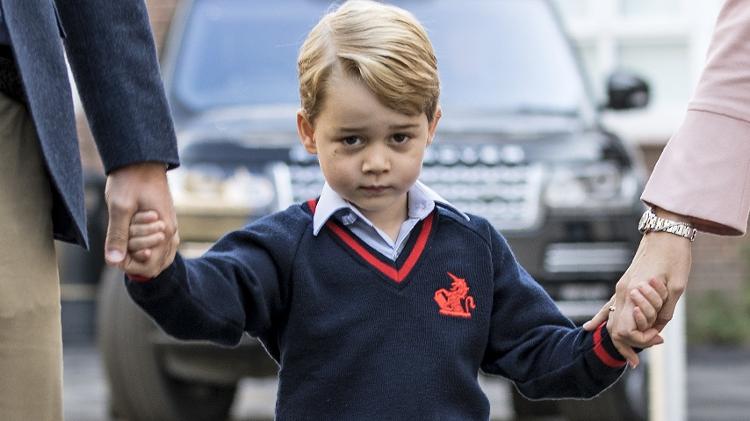 Príncipe George segura as mãos do pai e da diretora da escola - AFP - AFP