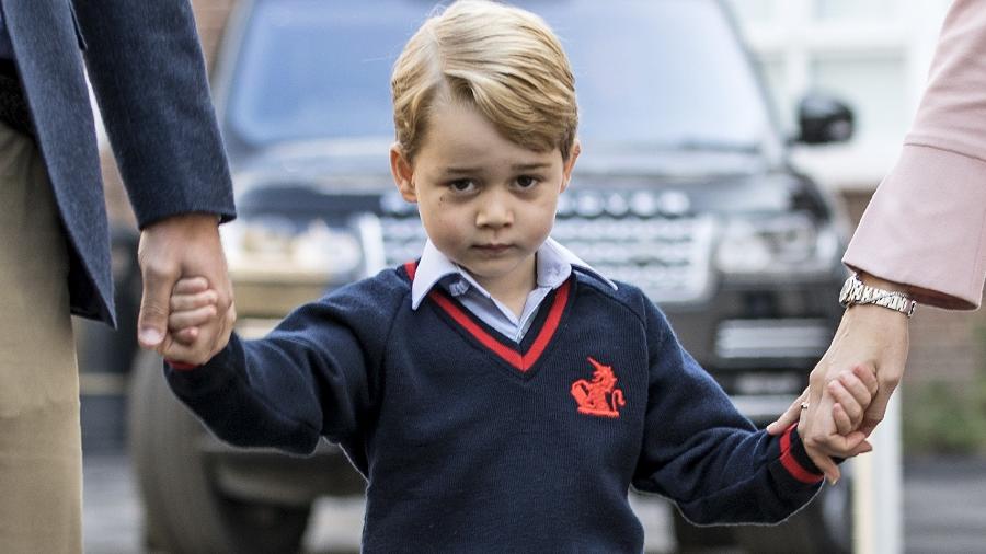 Príncipe George segura as mãos do pai e da diretora da escola - AFP