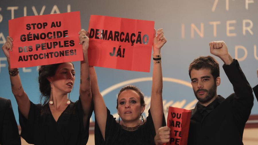 A produtora Isabella Nader e os diretores Renee Nader Messora e Joao Salaviza fazem prostesto em Cannes contra o genocídio indígena - AFP/ Valery HACHE