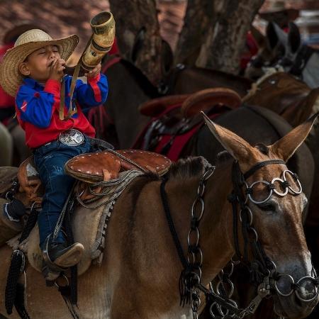 Garoto toca o berrante em cavalgada na cidade de Paragominas, Pará - Ricardo Teles