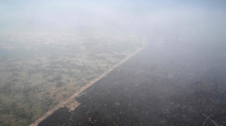 Imagem aérea de uma área de floresta amazônica desmatada e coberta pela fumaça de um incêndio ilegal no município de Cujubim (RO)