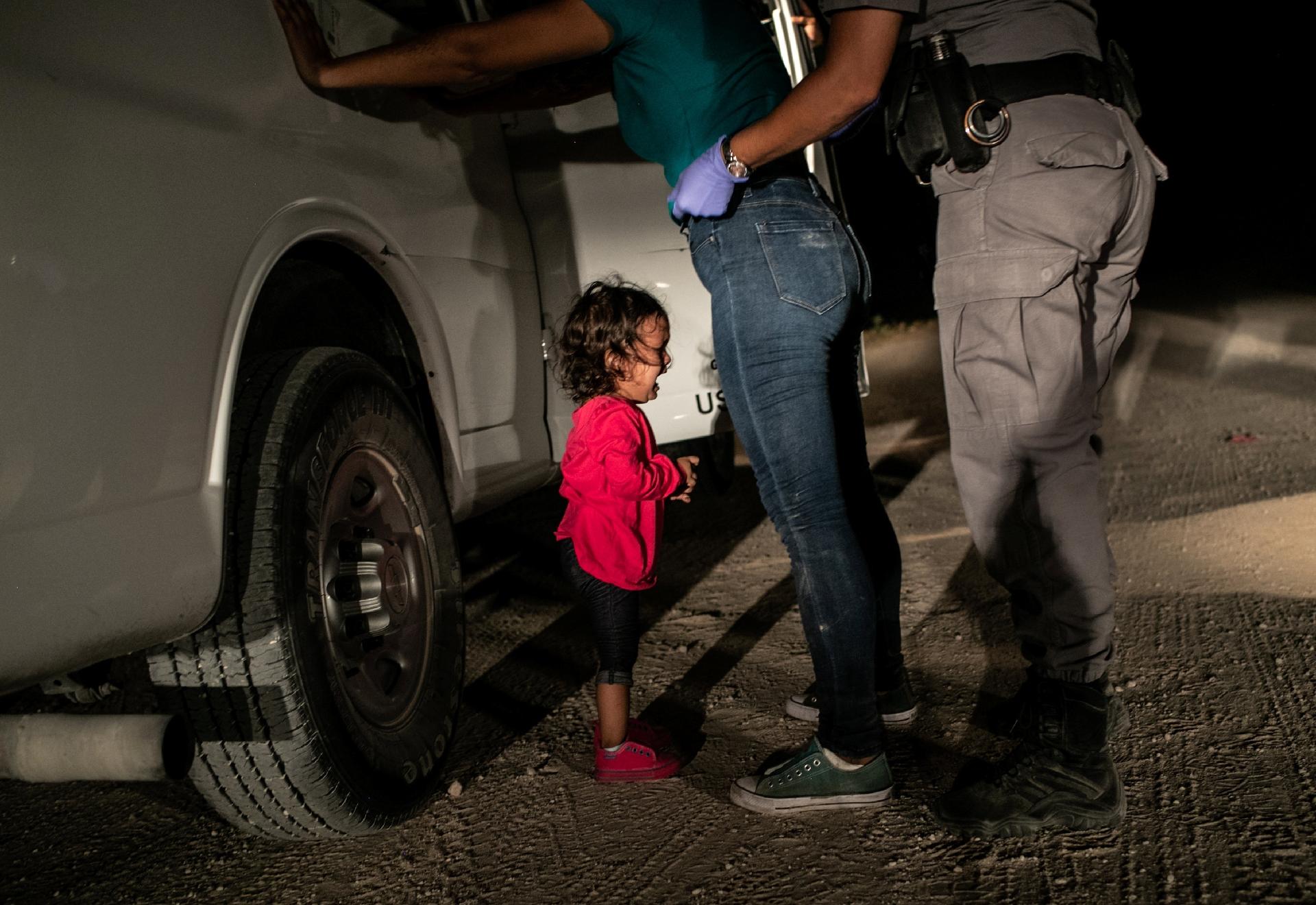 Yana, de Honduras, chora enquanto sua mãe, Sandra Sanchez, é revistada por agente de fronteira dos Estados Unidos - John Moore, for Getty Images/World Press Photo via REUTERS
