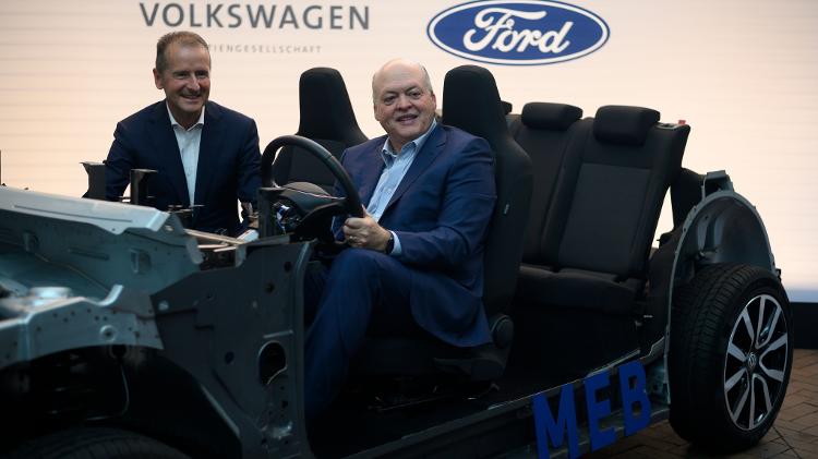 Jim Hackett, chefão da Ford, posa ao lado de Herbert Diess, da VW, ao volante de protótipo do hatch elétrico ID.3 - Johannes Eisele/AFP
